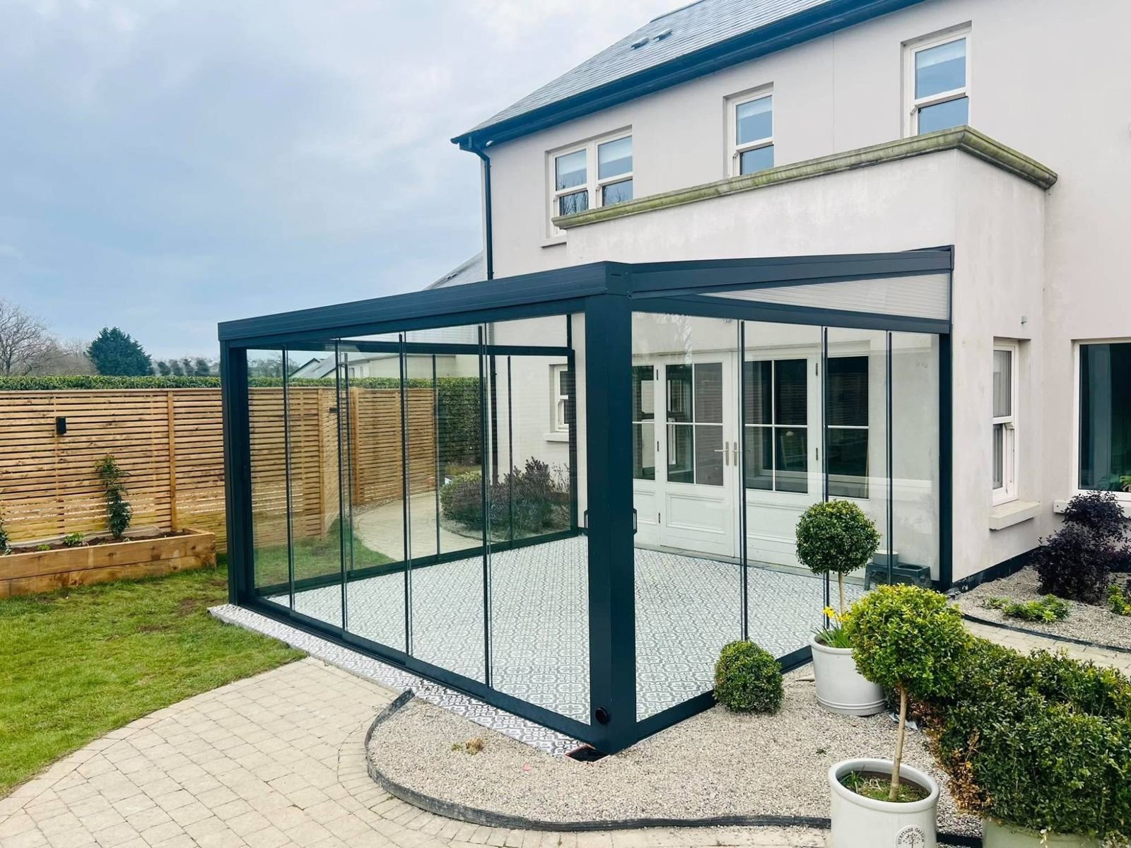 Veranda closed in with frameless sliding glass panels on two sides