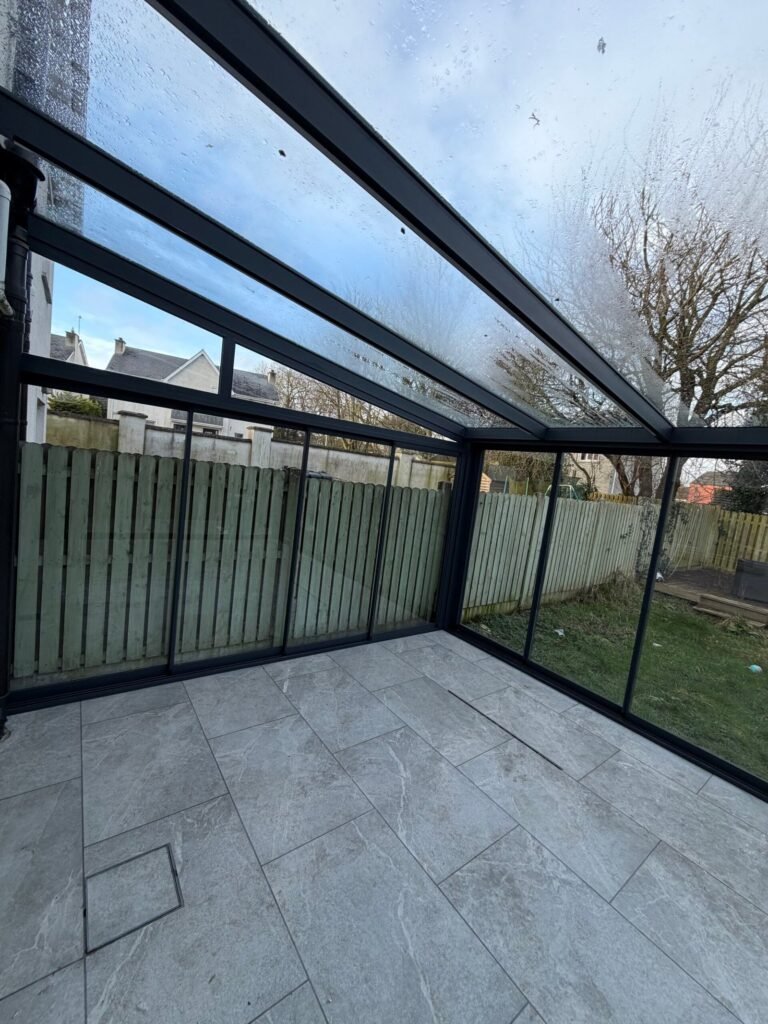 Glazed aluminium cube veranda seen from the garden