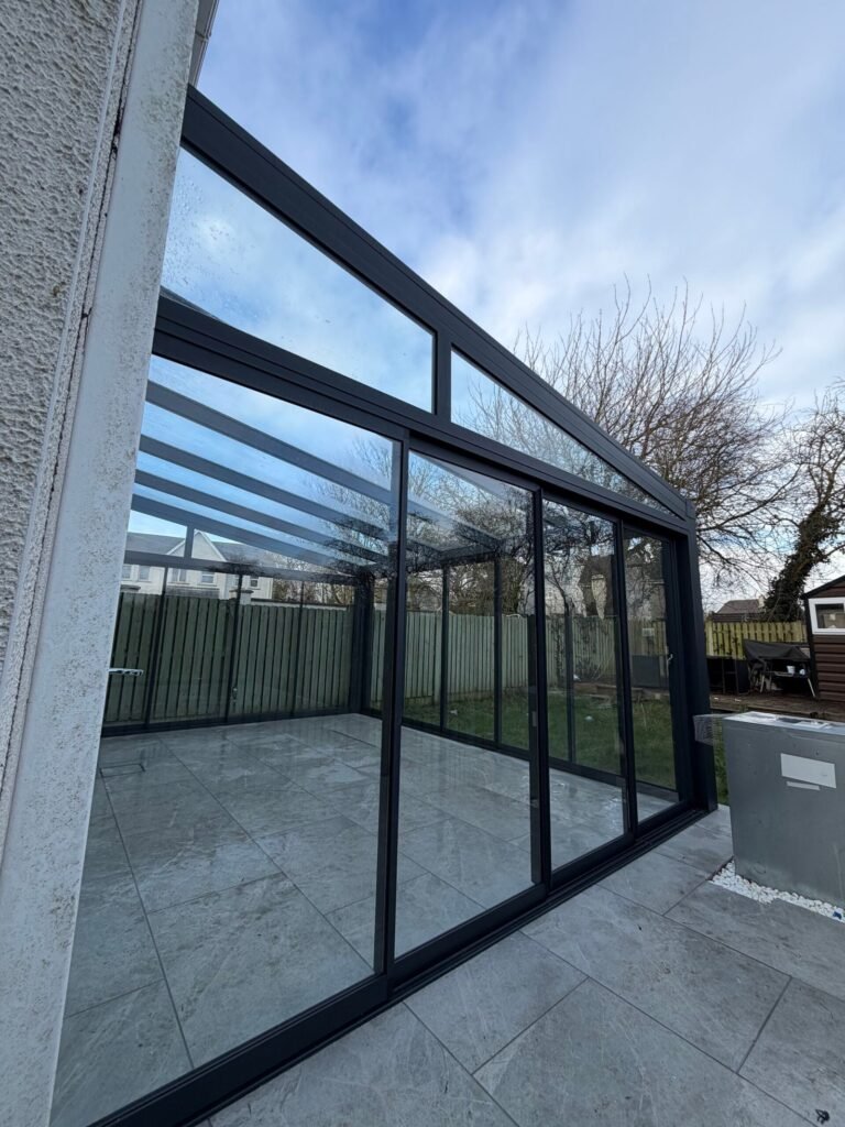 Aluminium veranda with sliding glass walls and a glass roof