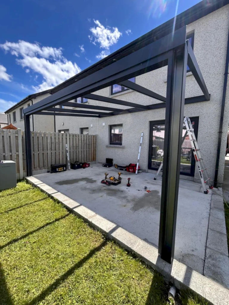 Aluminium pergola frame being installed in a back garden